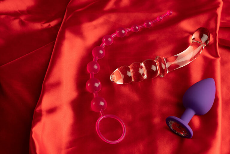 Verschiedene Sextoys auf rotem Samt Stoff